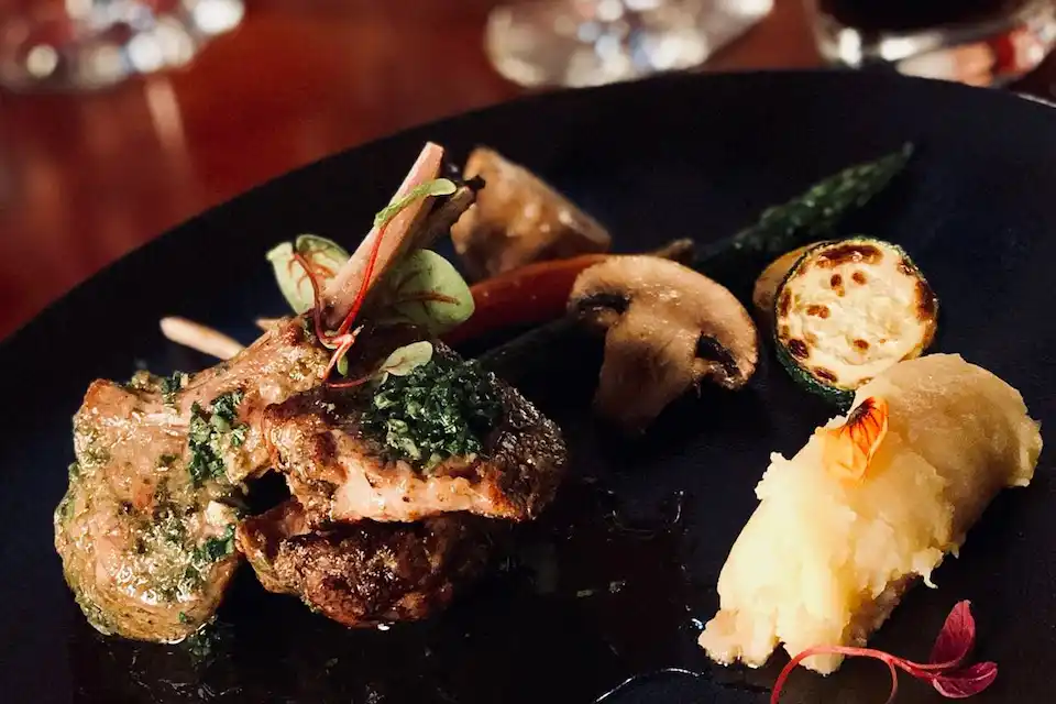 Gourmet lamb chops with seasonal vegetables and mashed potatoes at Mashpi Lodge, an eco-luxury retreat in Ecuador.