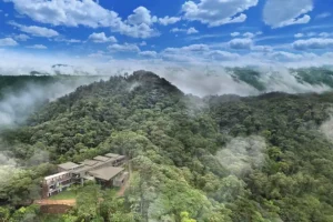 Mashpi Lodge aerial view, nestled in the Ecuadorian cloud forest, shrouded in mist, embodying a serene eco-retreat.