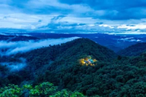Mashpi Lodge, a beacon of light in the Amazon Rainforest, stands out against the twilight hues of the dense Ecuadorian jungle.