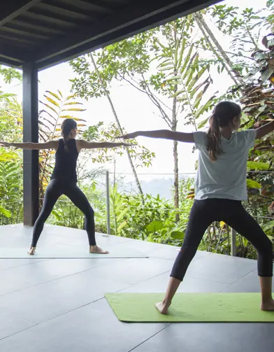 mashpi lodge yoga ejercicio Individuals practicing yoga at Mashpi Lodge with a backdrop of the cloud forest.