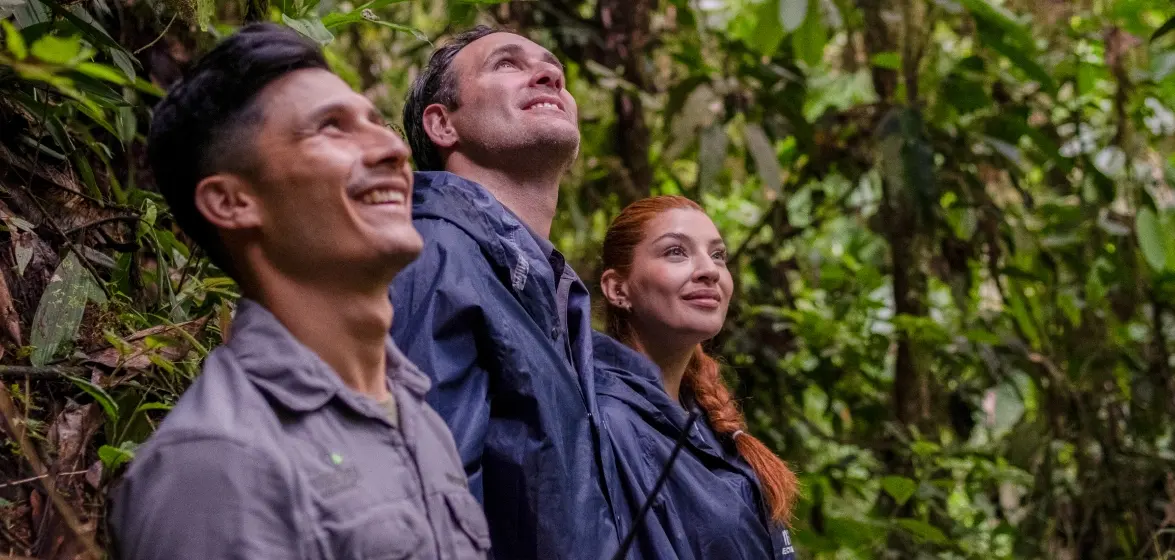 Ecoturistas llenos de asombro mientras exploran la biodiversa Reserva Mashpi, un lujoso refugio en la selva nublada de Ecuador.